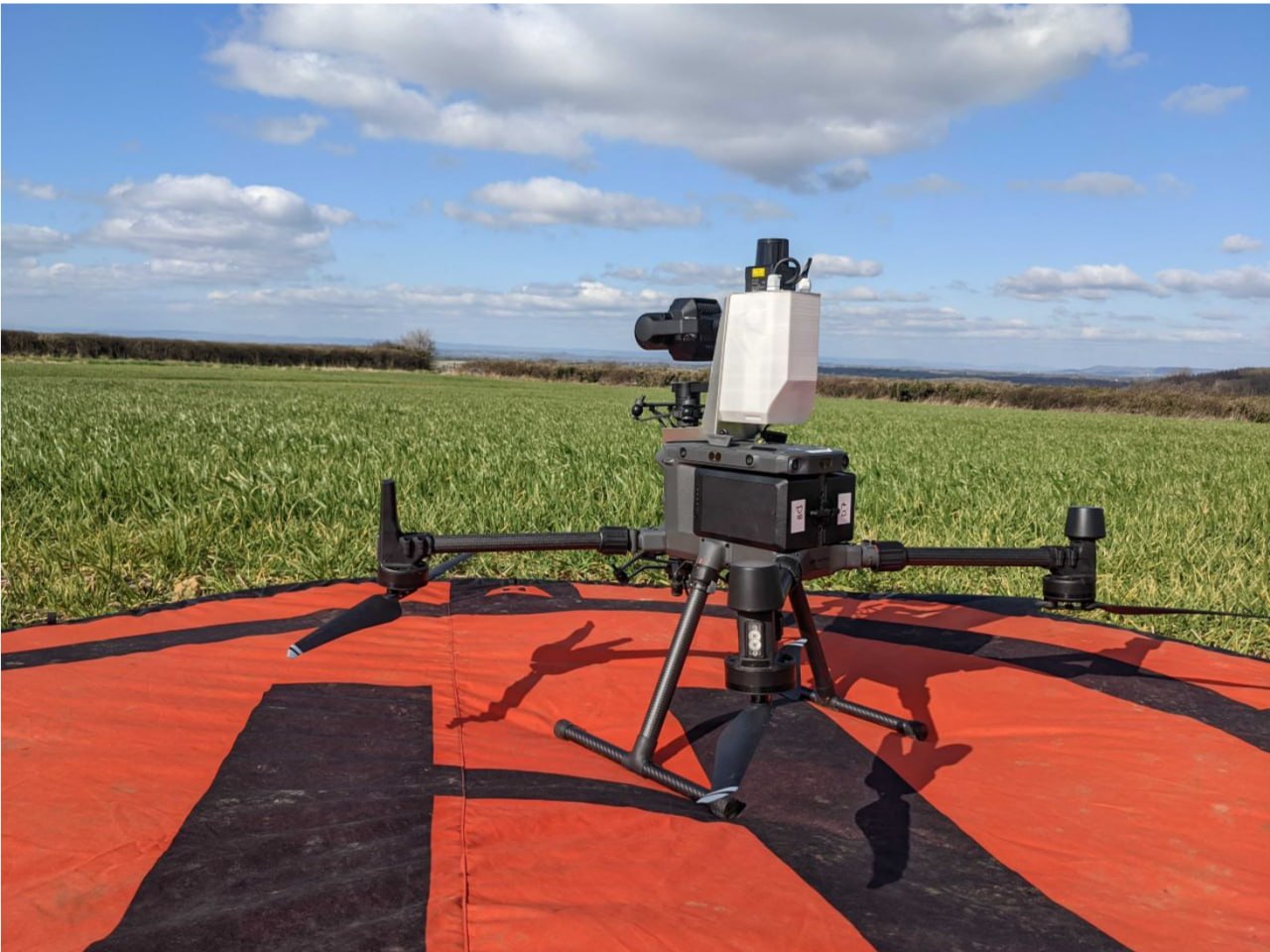 Drone-based inspection system positioned on a landing marker in an open field